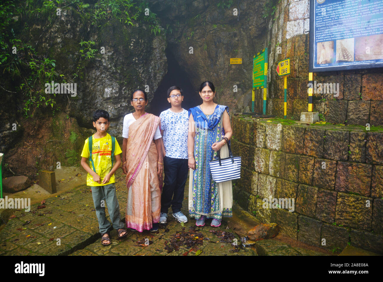 Una famiglia indiana composta da madre e figlia figli in posa di fronte alle grotte di Cherrapunjee progetto ecologico conoscere noto come altopiano Sohra Foto Stock