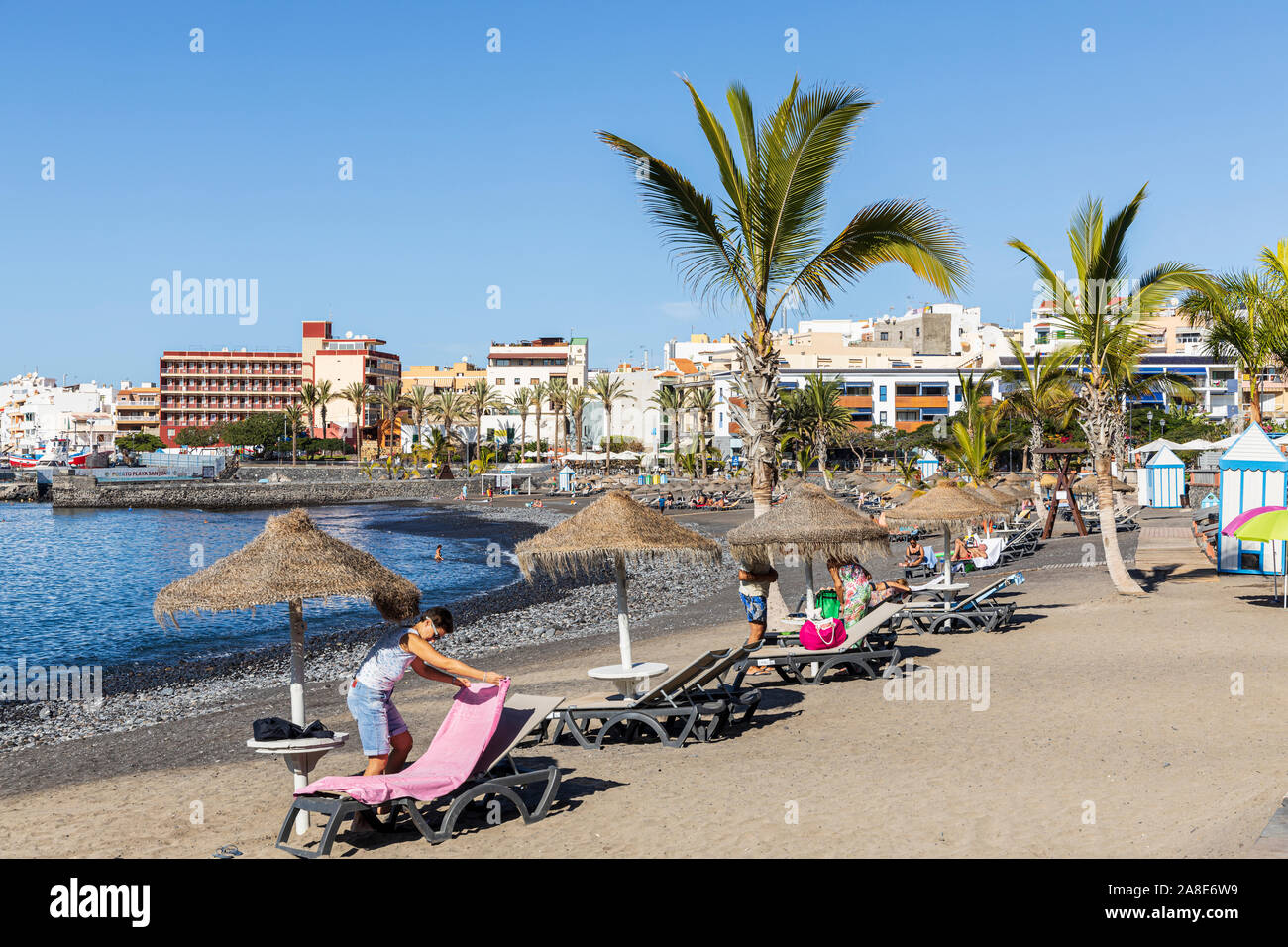 Turisti e palme sulla spiaggia a Playa San Juan, Tenerife, Isole Canarie, Spagna Foto Stock