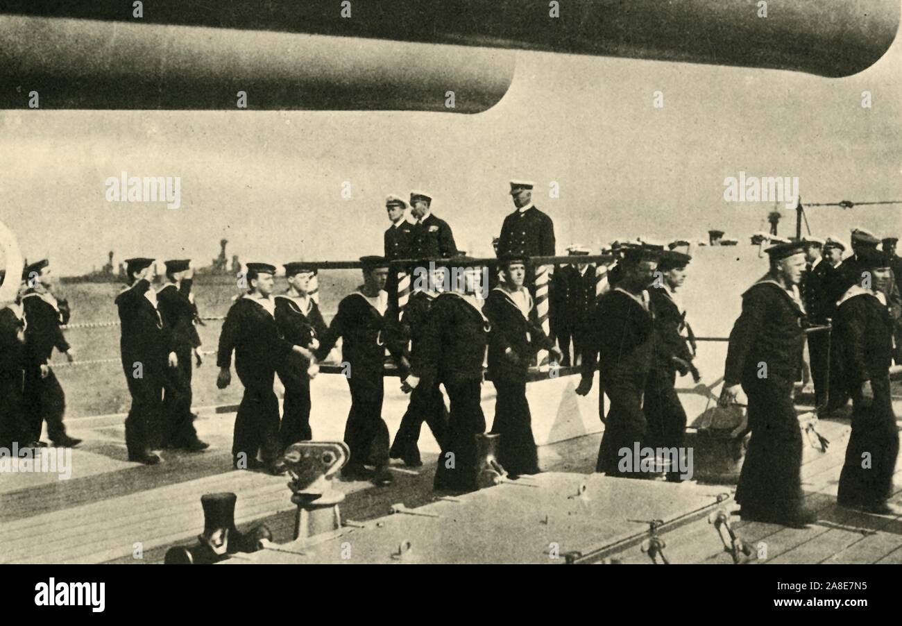 "Il Re della visita al Grand flotta', la prima guerra mondiale, giugno 1917 (c1920). '...Bluejackets [marinai della Royal Navy] marching passato sua maestà [King George V] a bordo di una delle corazzate" presso la Scapa fluire della costa nord della Scozia. George's figlio Principe Albert (più tardi re George VI), era in servizio a bordo di HMS 'Malaya' al momento. Da "La Grande Guerra Mondiale: una storia", Volume VII, edito da Frank un Mumby. [Il Gresham Publishing Company Ltd, Londra, c1920] Foto Stock