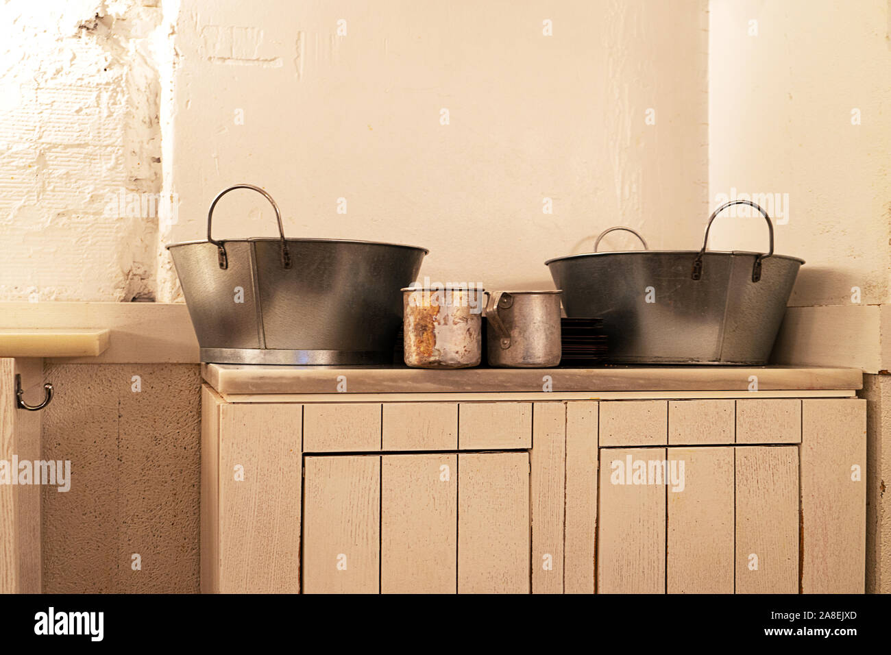 Interno di una vecchia taverna ristorante con il vecchio color crema con arredi di legno e utensili da cucina in metallo. In stile vintage. Foto Stock