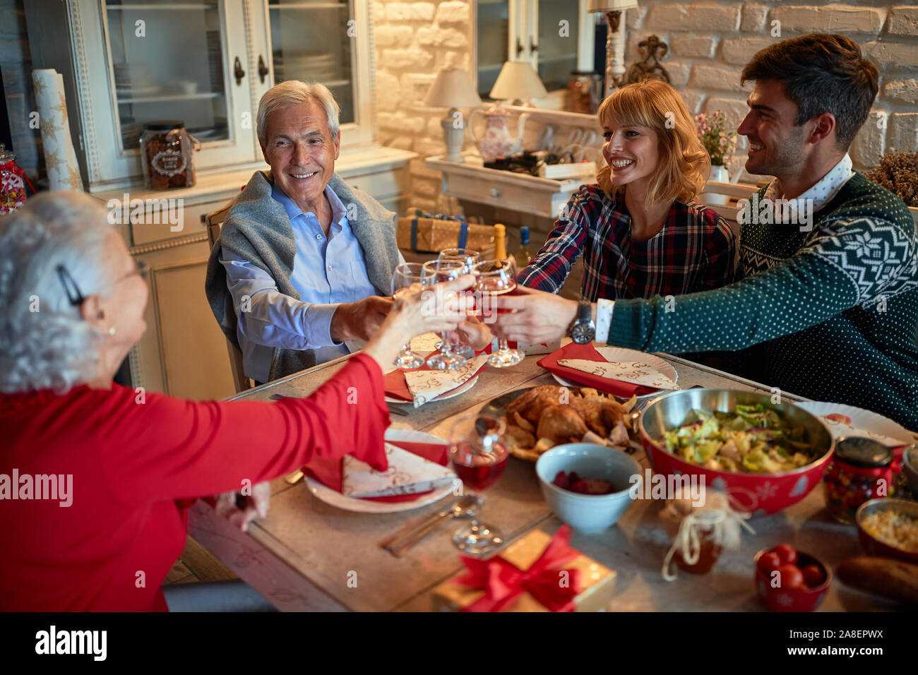 Generazione Famiglia festeggiano il Natale a casa di bere vino rosso a casa Foto Stock