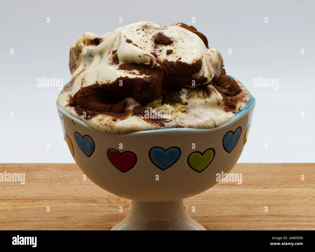 Coppa del tiramisù gelato sul tavolo di legno, sfondo bianco. Foto Stock