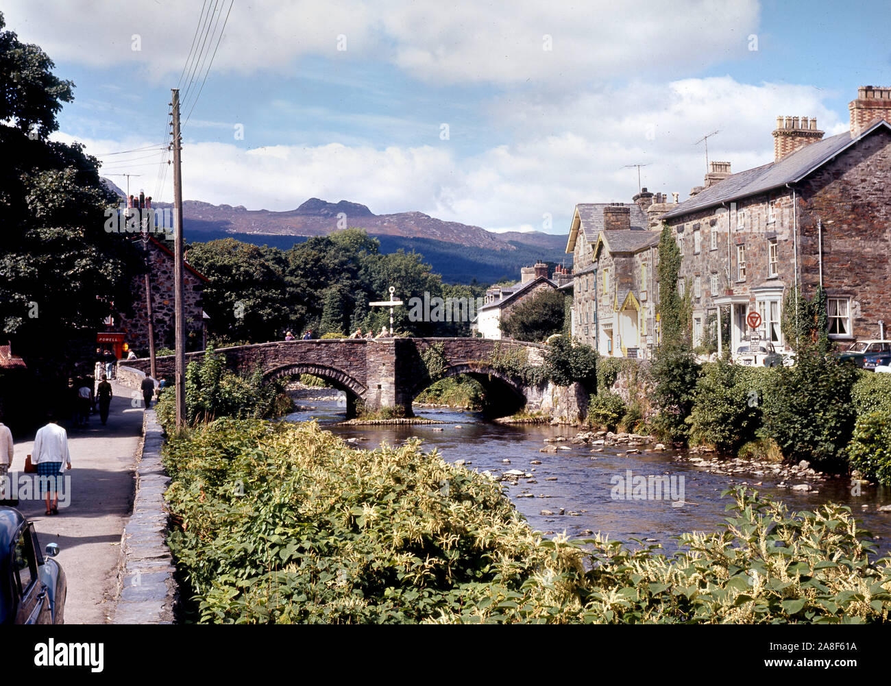 Ponte di pietra sul fiume Colwyn nel villaggio di Beddgelert, Parco Nazionale di Snowdonia, Gwynedd, il Galles del Nord 1964 Foto Stock