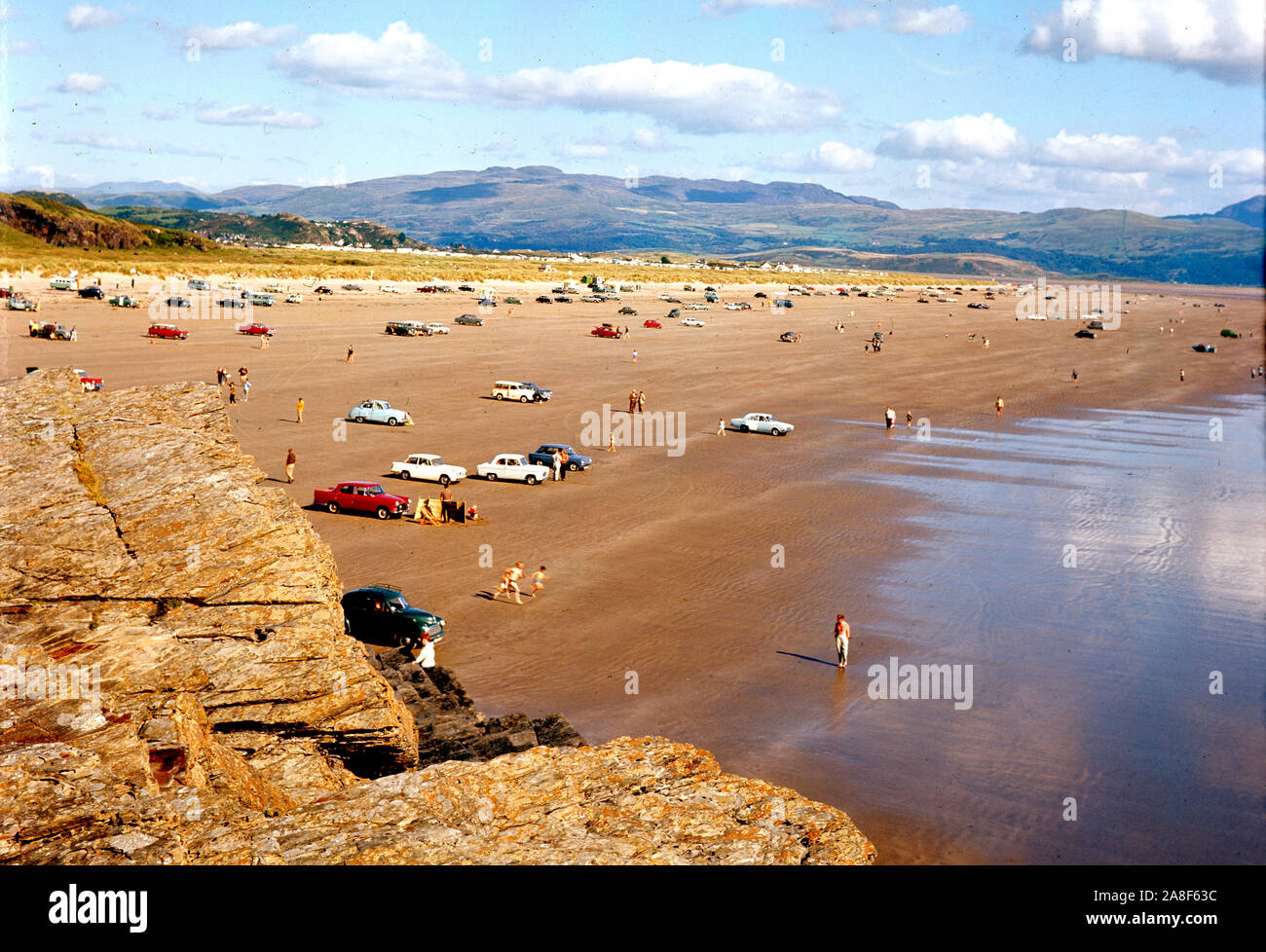 Auto sulla spiaggia vicino a Porthmadog in Galles 1964 Foto Stock