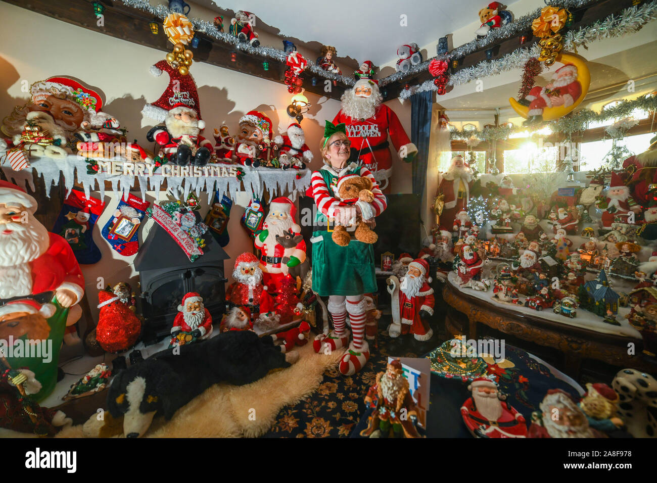 Swansea, Wales, Regno Unito. 8 novembre 2019. Nella foto è Betty-Ann Jones da Pontardawe vicino a Swansea, Galles, che ha speso migliaia di sterline per trasformare la sua casa in un paese delle meraviglie di Natale. Nonna, Betty-Ann, chi spende settimane di impostazione display, riempie ogni centimetro della sua casa con decorazioni ogni anno per raccogliere fondi per le associazioni di beneficenza locali e Macmillan. Sono incluse le 14.000 luci fairy, 73 pupazzi di neve nella sala TV e più di 200 in miniatura case di Natale. Lei è diventato noto localmente come la onorevole Natale. Robert Melen/Alamy Live News. Foto Stock