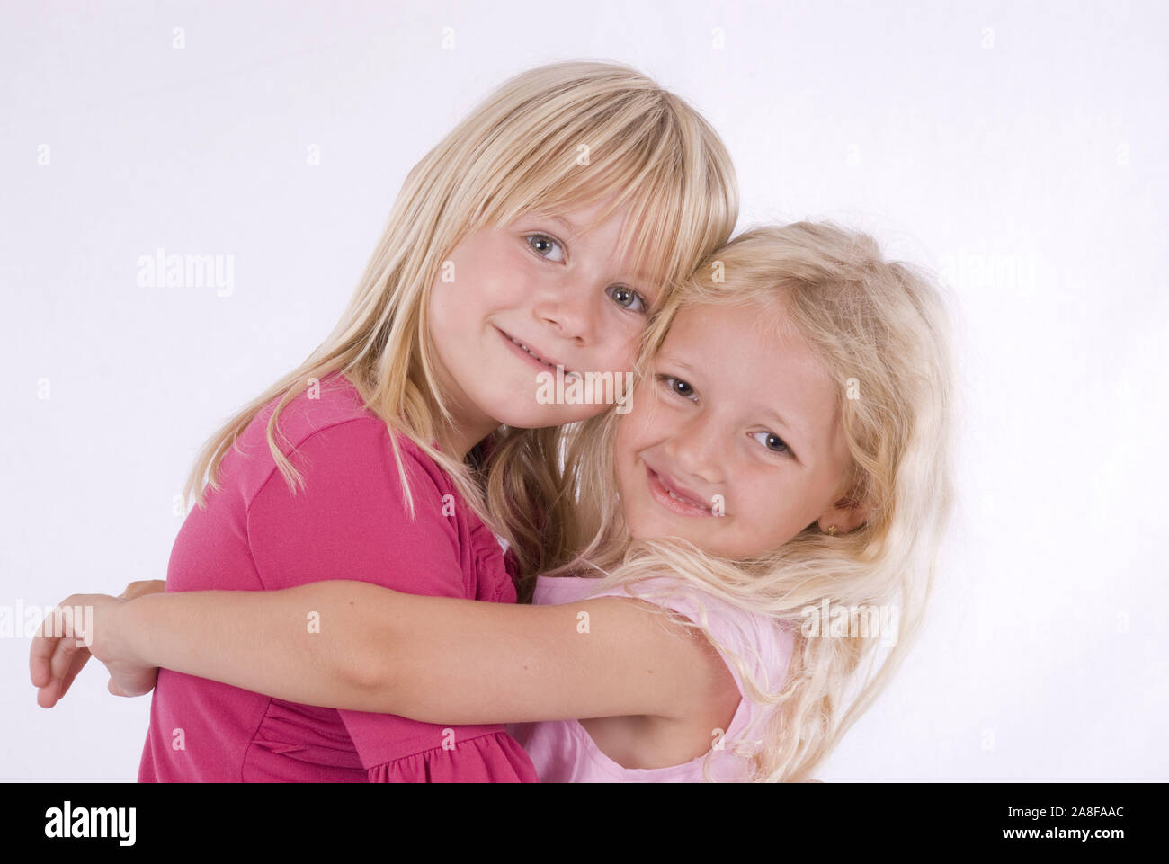 Zwei, Mädchen, Freunde, 6 und 7 Jahre alt, umarmen sich herzlich, signor:Sì Foto Stock