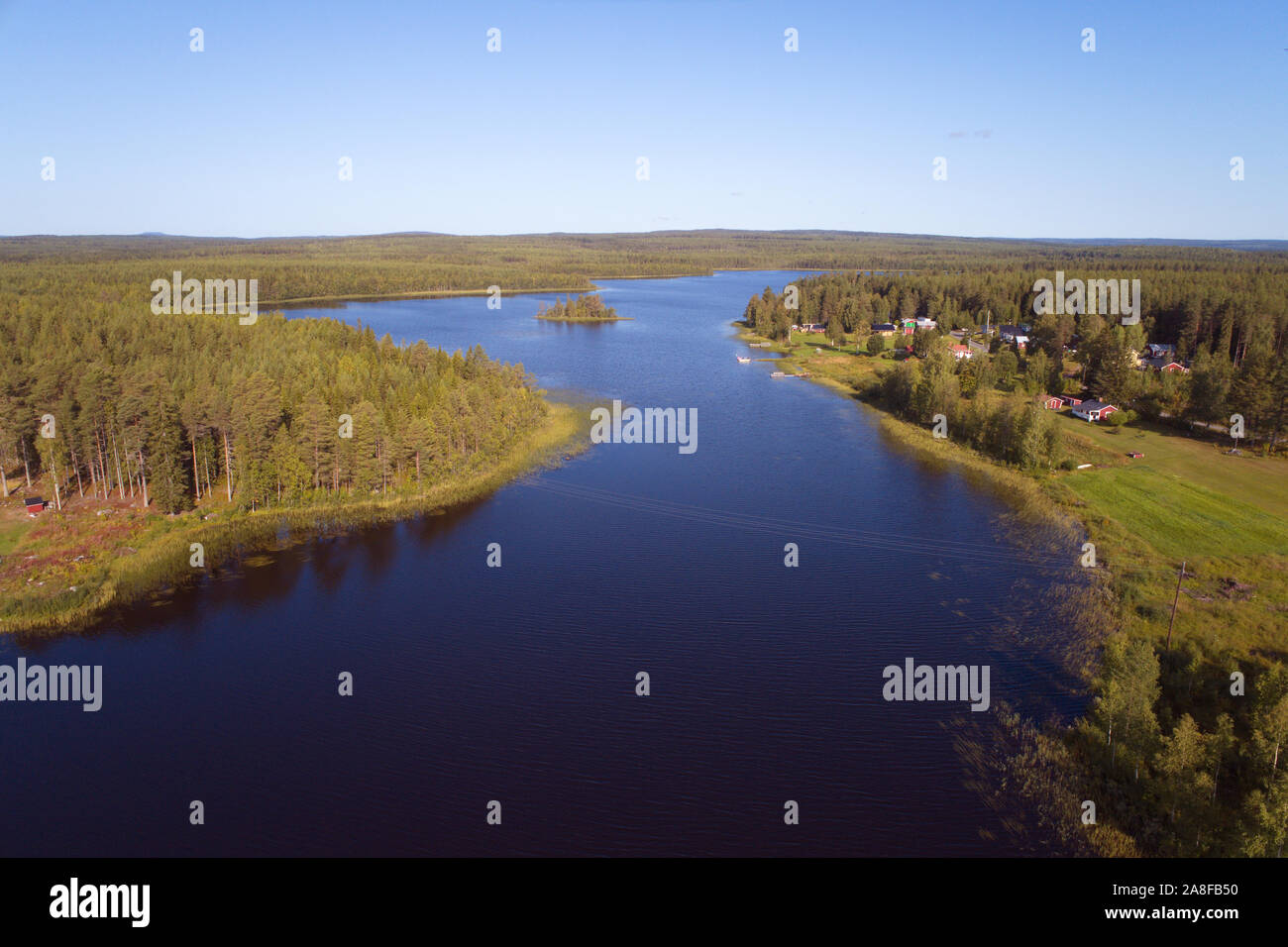 Veduta aerea woodland paesaggio con un lago e un froup di case si trova nella parte settentrionale della Svezia. Foto Stock