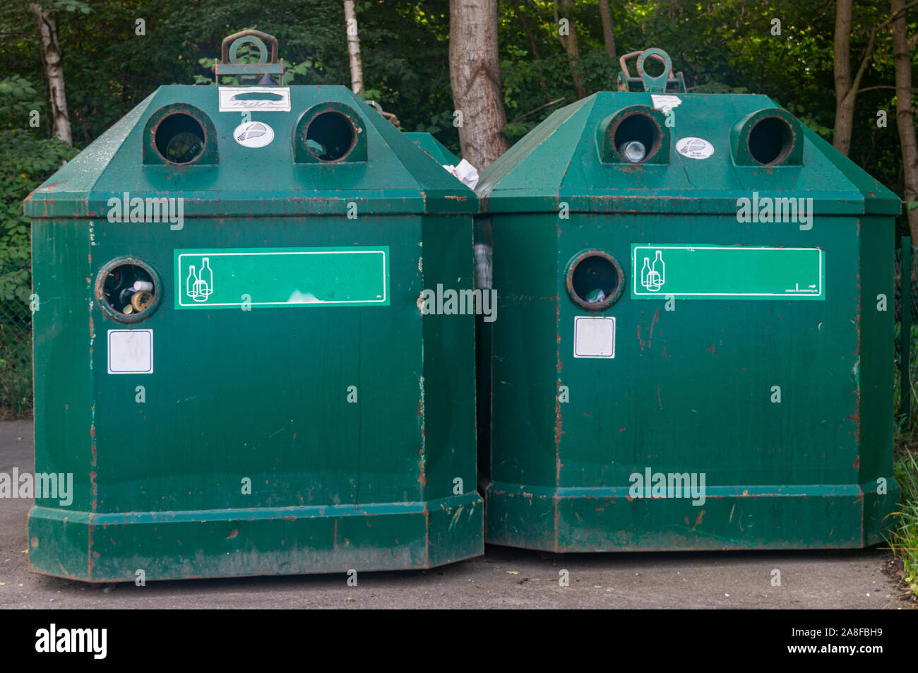 Verde dumpster di ferro per il vetro sulla strada closeup. Contenitore di riciclaggio Foto Stock