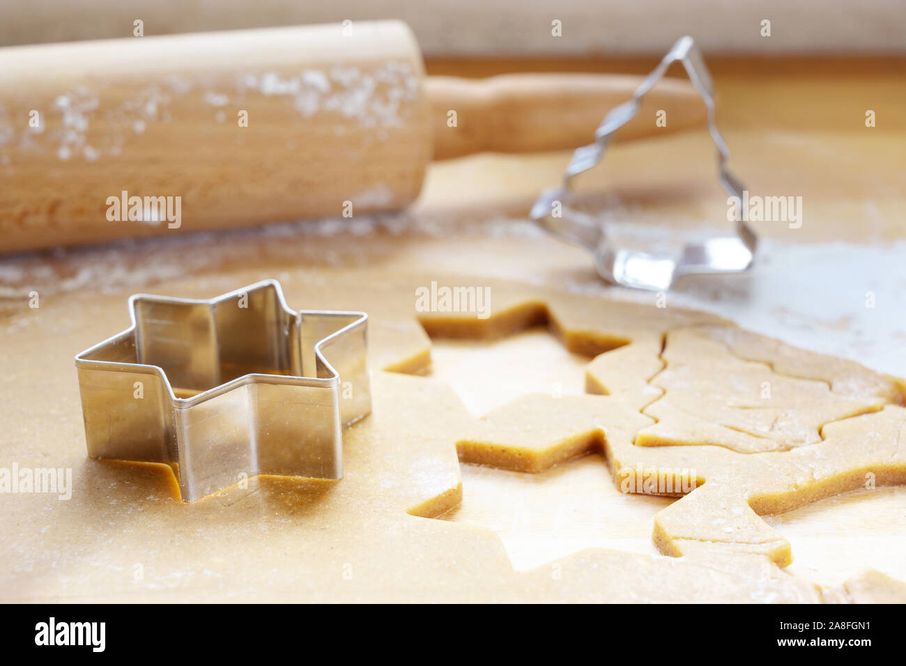 La cottura per Natale, pasta laminata con cookie cutters in star e abete forma tradizionale per pan di zenzero, scelto focus, esigua profondità del fie Foto Stock