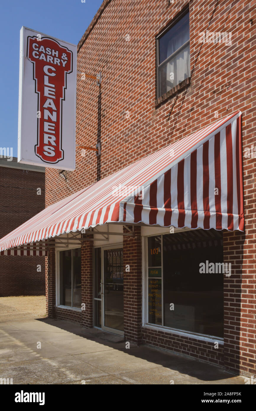 Il rosso Tenda a strisce del Cash & Carry pulitori evidenzia l edificio di mattoni rossi in piccole città America, Hattiesburg MS, STATI UNITI D'AMERICA Foto Stock