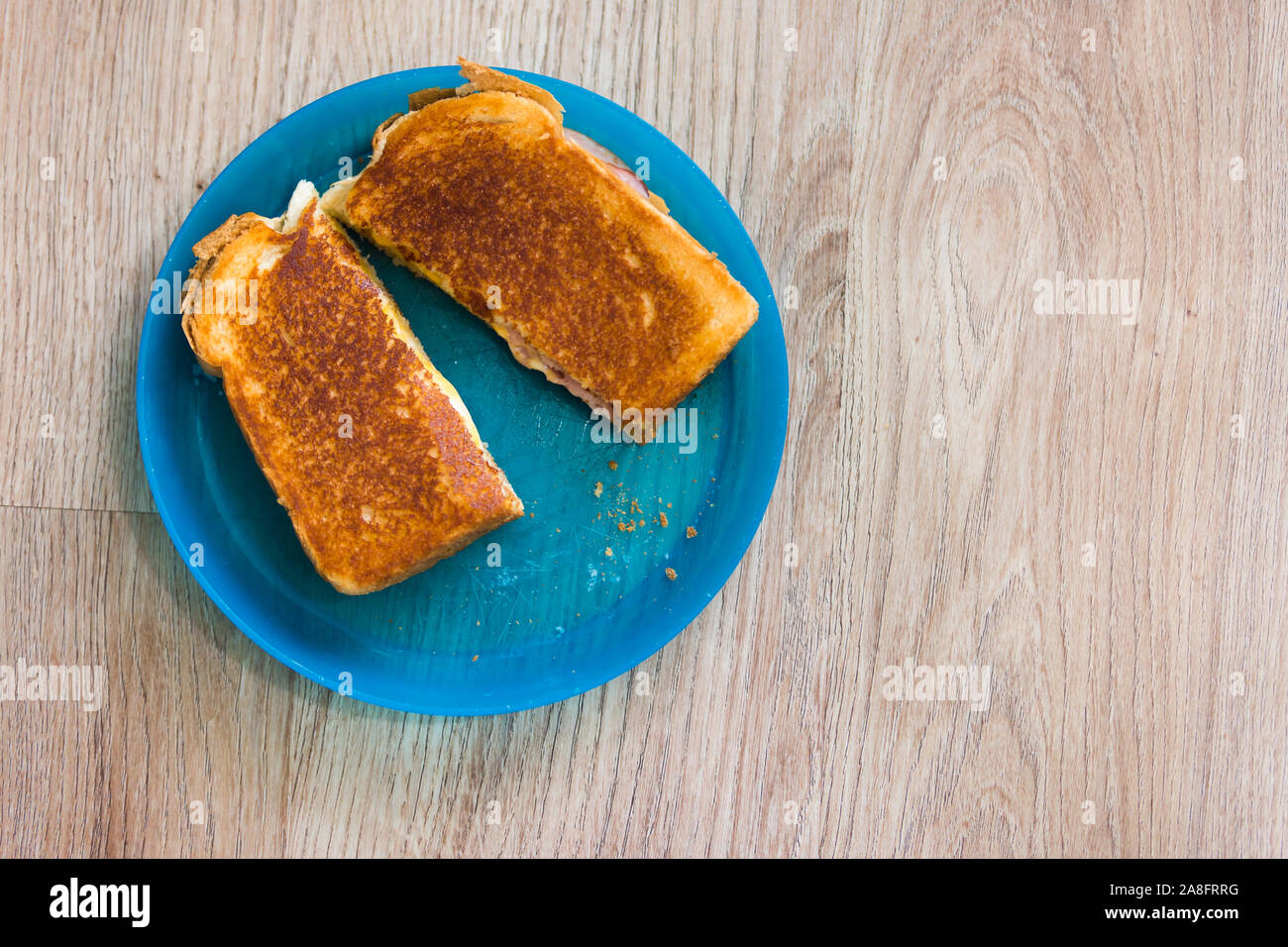 Golden brown formaggio alla griglia panino tagliato e servito sul bambino della targa Foto Stock