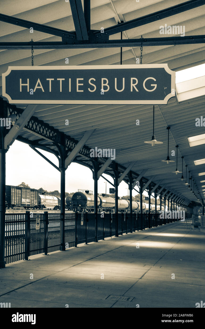 Tettoia di overhead per passeggeri area di attesa per imbarco Hattiesburg MS, deposito dei treni, con targa e segno di petroliere nelle vicinanze, Hattiesburg, Foto Stock