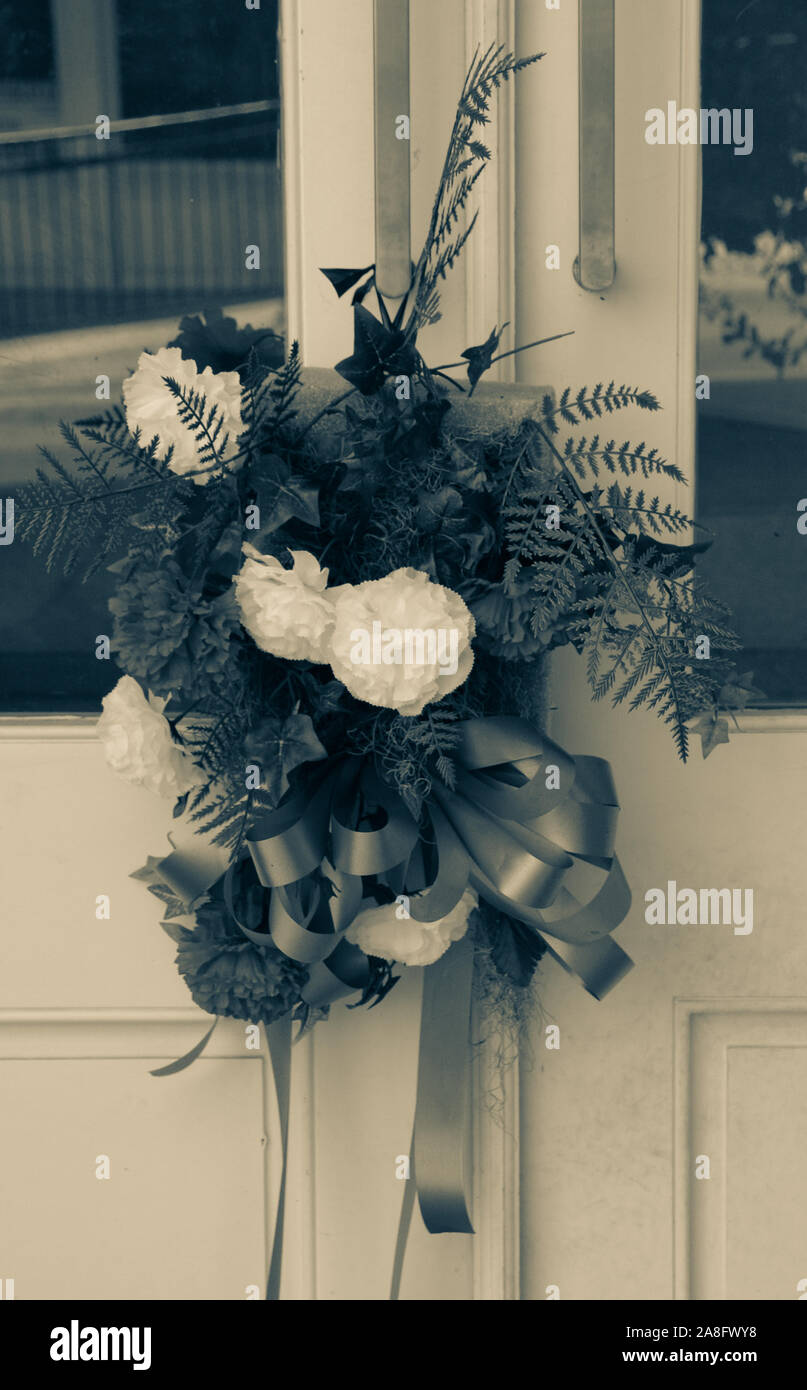 Un lutto bouquet di rosso, bianco e blu garofani su una porta anteriore simboleggia la simpatia per il defunto familiari nella piccola città America, STATI UNITI D'AMERICA Foto Stock