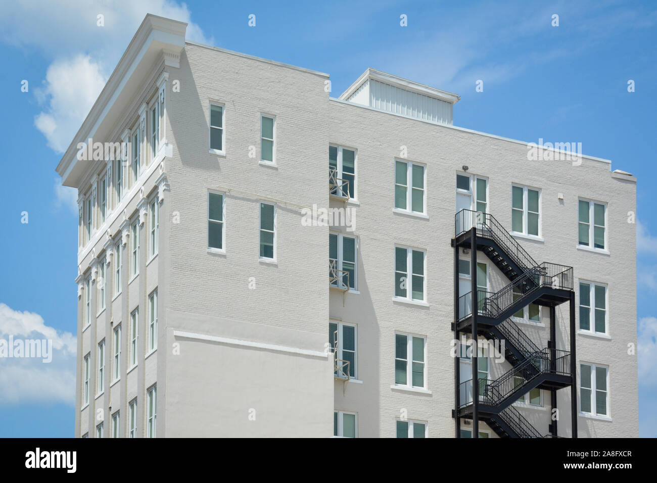 Un contrasto tra un moderno black iron fire escape su un vintage edificio di mattoni bianchi con accenti minimalista in Hattiesburg MS, STATI UNITI D'AMERICA Foto Stock
