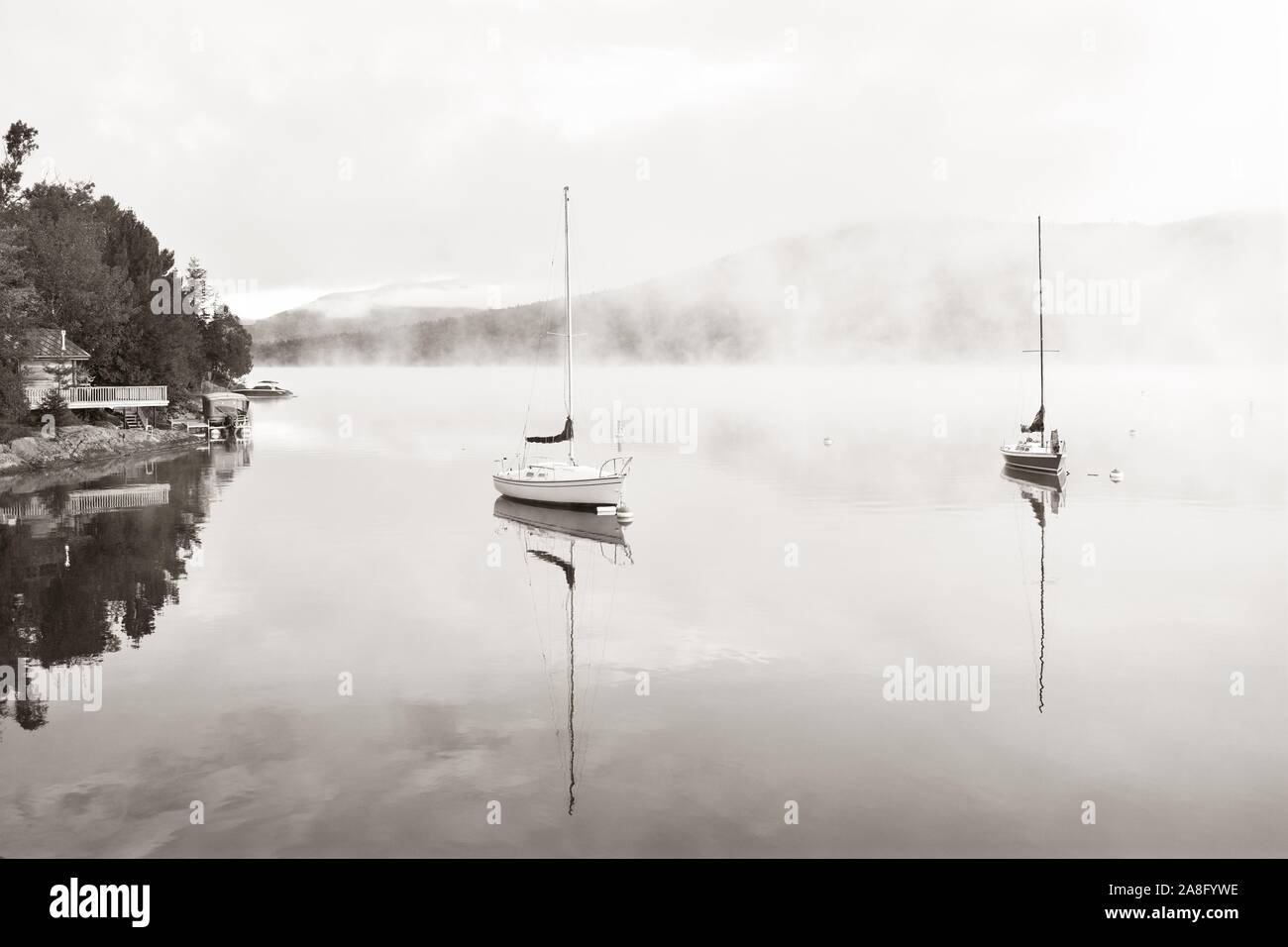 Barca in mattinata nebbiosa lago a sunrise a Mont Tremblant in Canada Foto Stock
