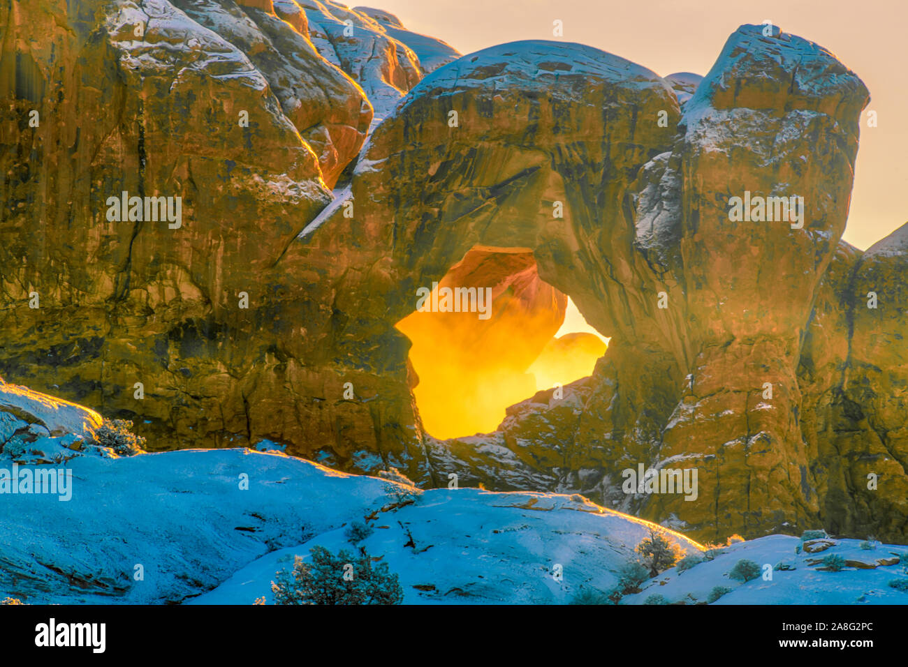 Inverno nebbia a doppio arco, Parco Nazionale di Arches, il sole illumina la nebbia intrappolato in arch alcova, sezione di Windows Foto Stock