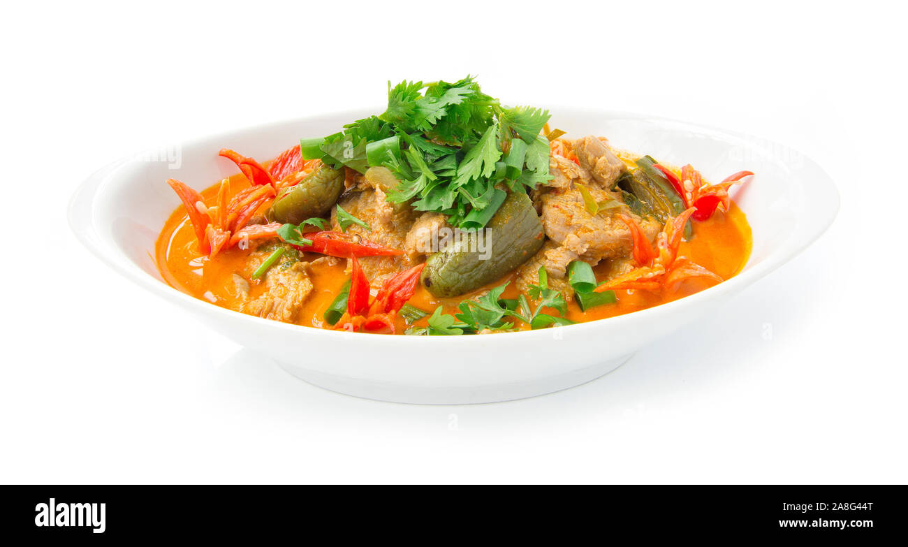 Red Curry maiale con latte di cocco (Kang phed muu) Thaifood curry stile spisy guarnita con coriandolo decorare scolpiti chili vista frontale isolato su bianco b Foto Stock