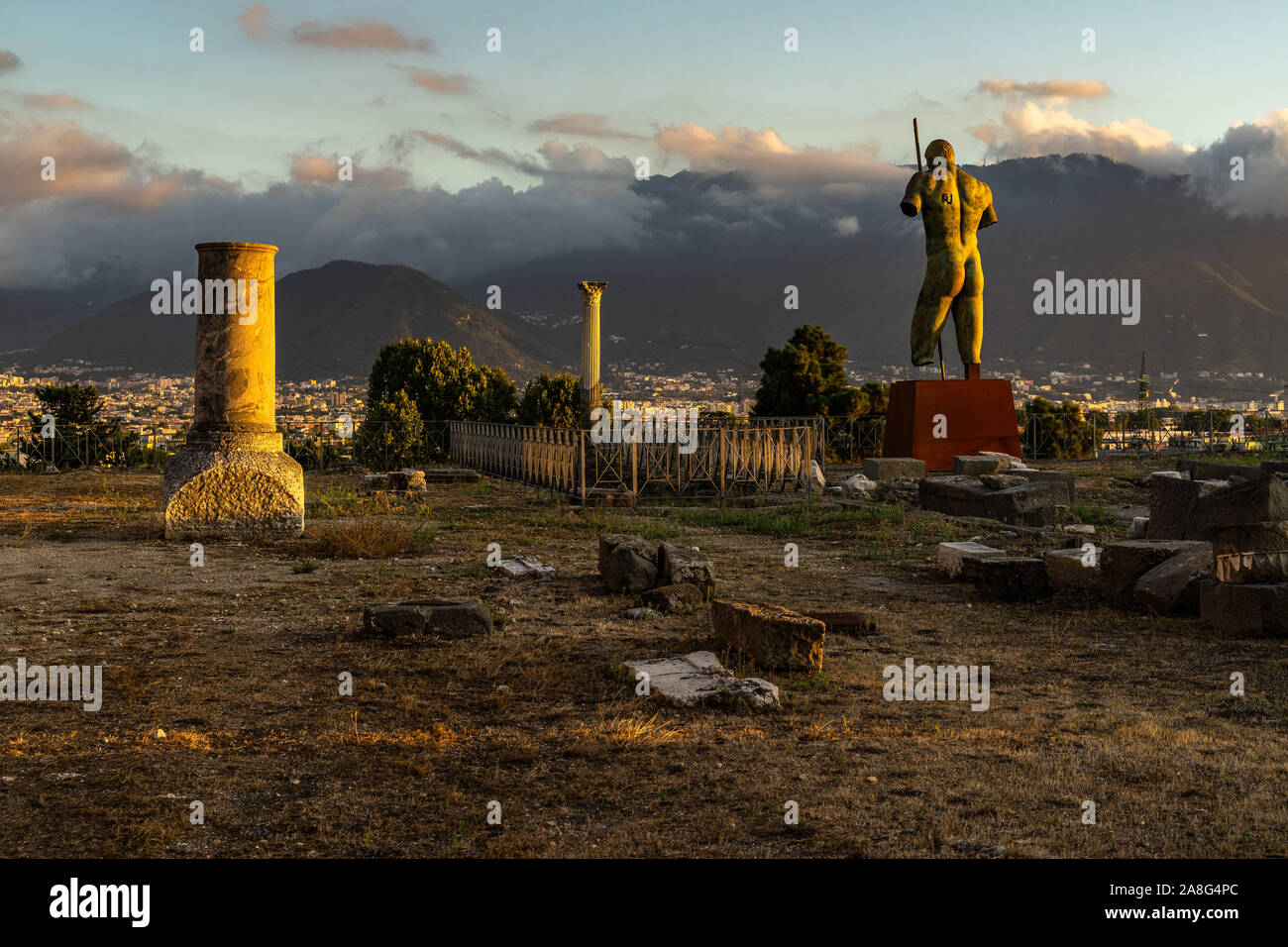 Daedalus statua di Igor Mitoraj affacciato su rovine di Pompei al tramonto, Campania, Italia Foto Stock