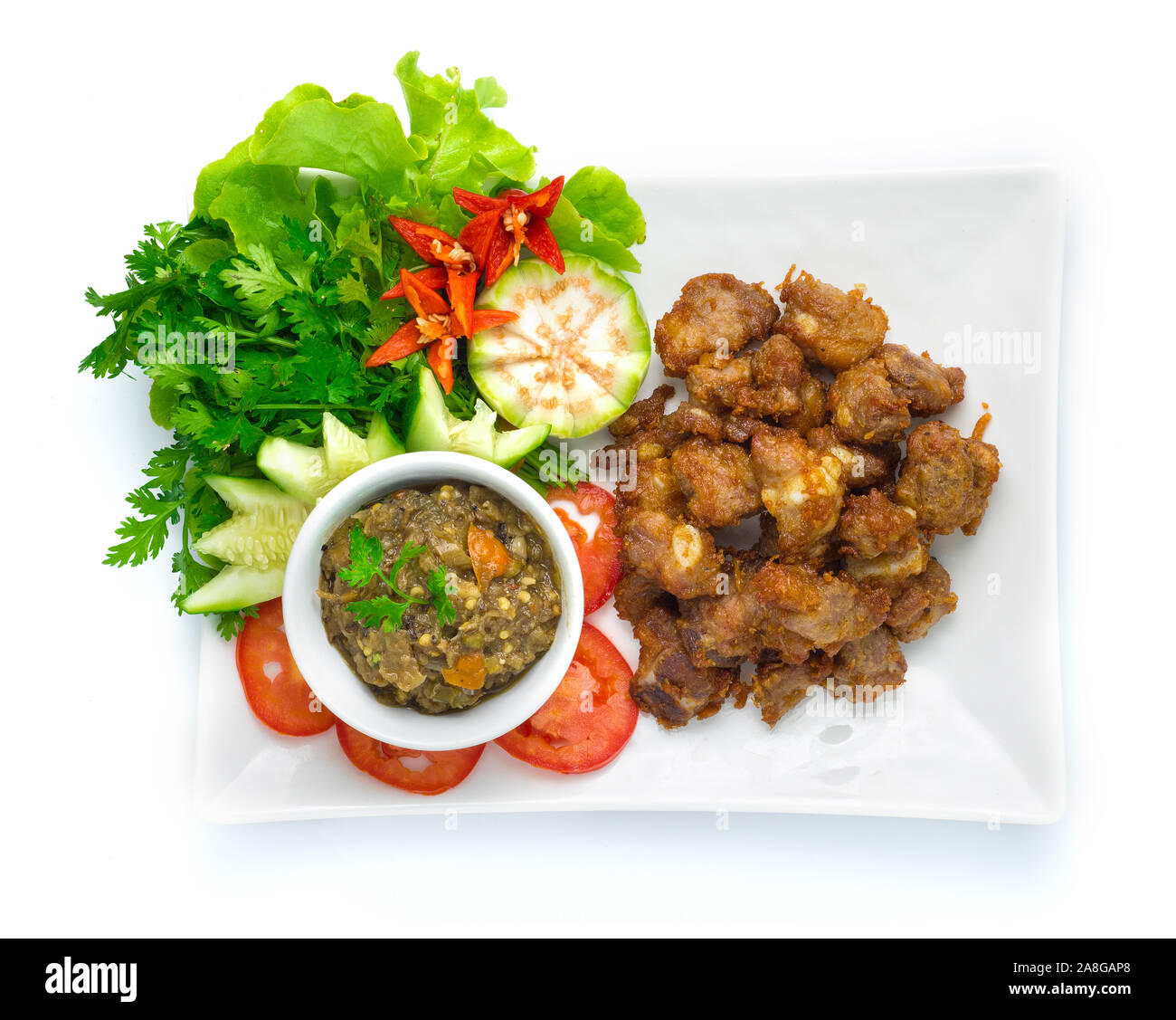 Maiale fritto costine servita con pasta di peperoncino decapati pesce cibo Thailandese in stile fusion decorare con verdura intagliata, di Cetrioli Melanzane, peperoncino e corian Foto Stock