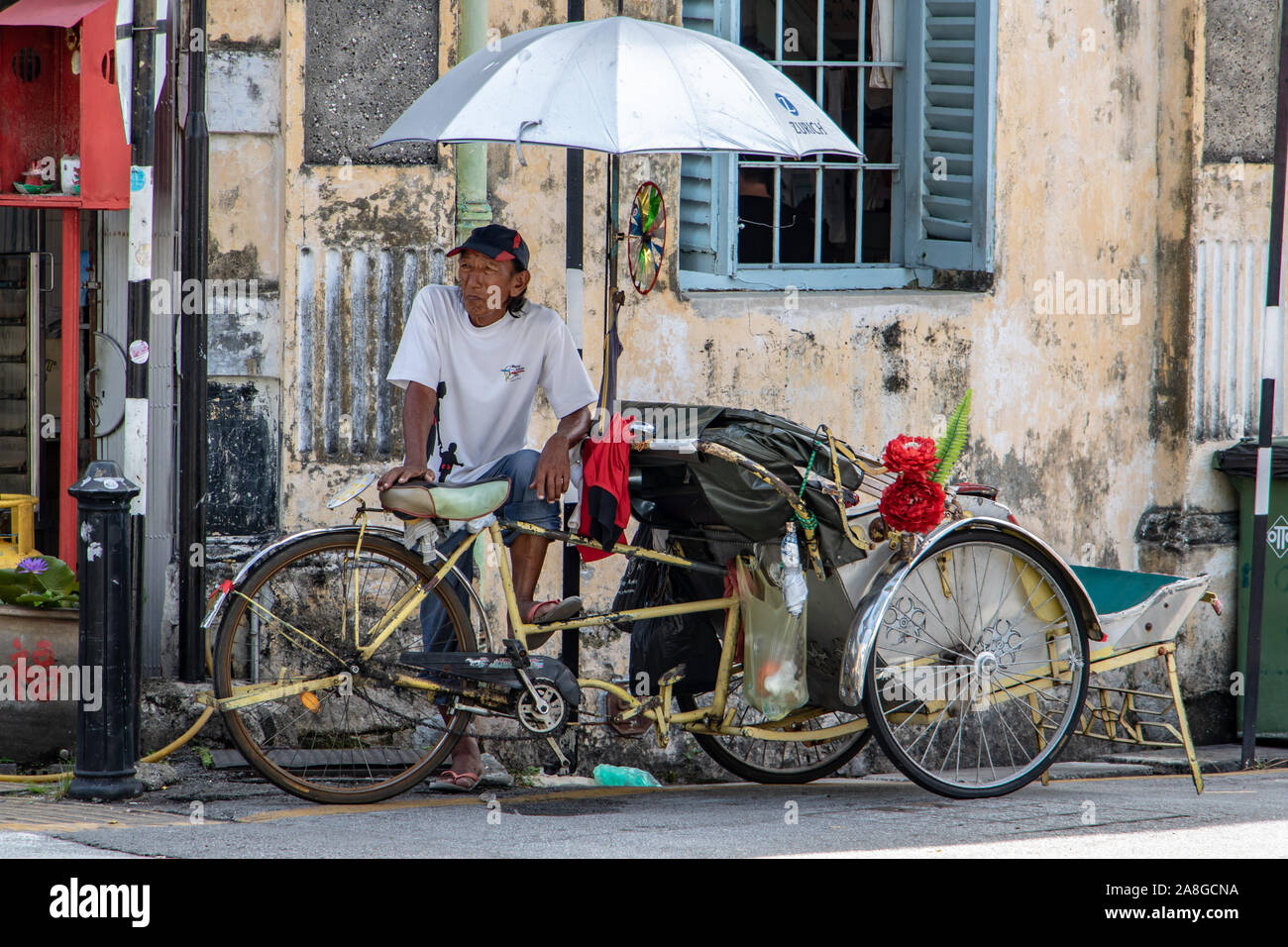 PENANG, MALAYSIA, NOV 12 2017, un triciclo tradizionale in strada di Penang. Un autista decorate rickshaw attende per un passeggero. Foto Stock