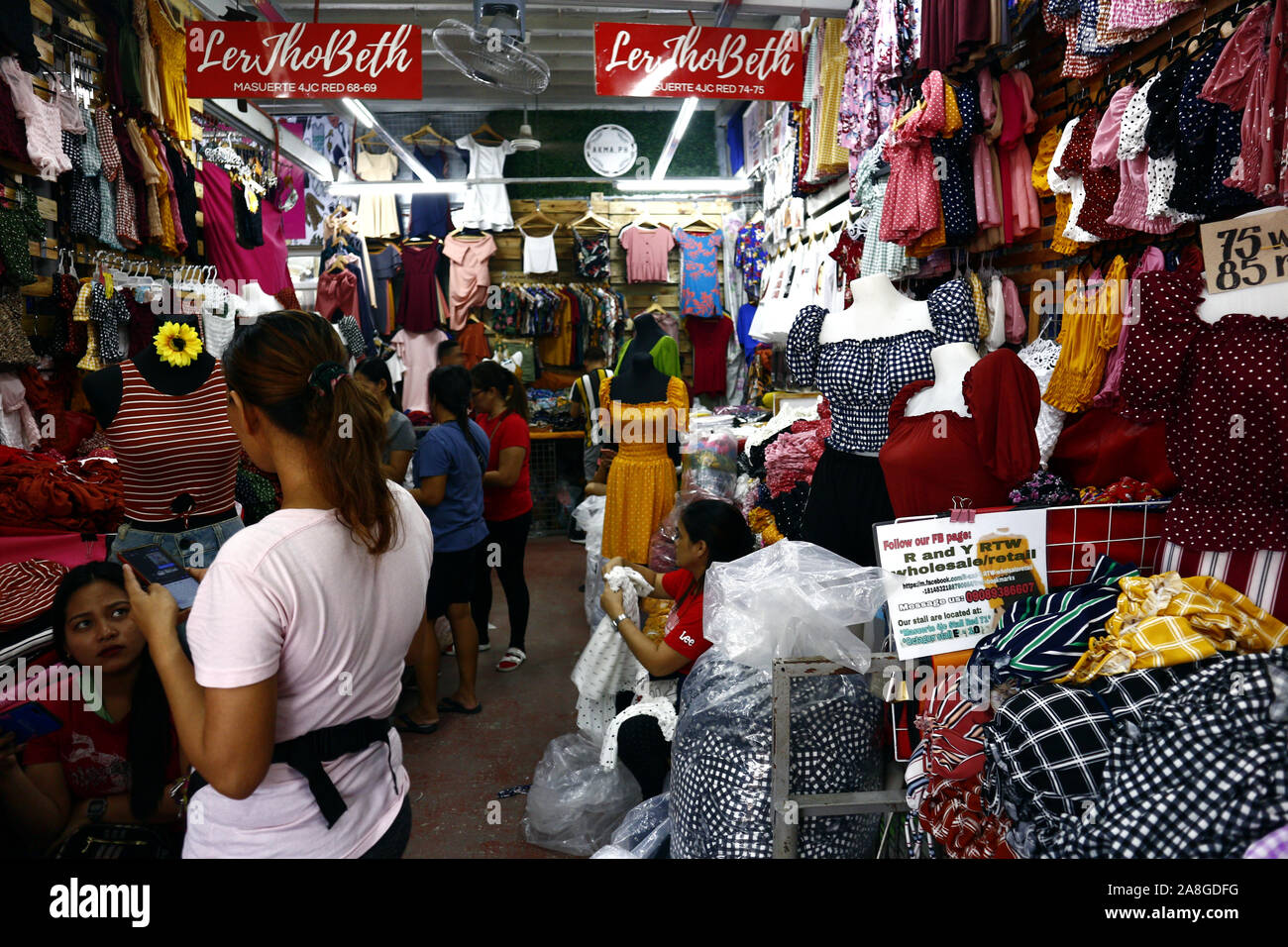 TAYTAY, Rizal, Filippine - 7 Novembre 2019: conveniente assortiti di abbigliamento e calzature sul display in un bazar stallo a un famoso bazaar luogo o loca Foto Stock