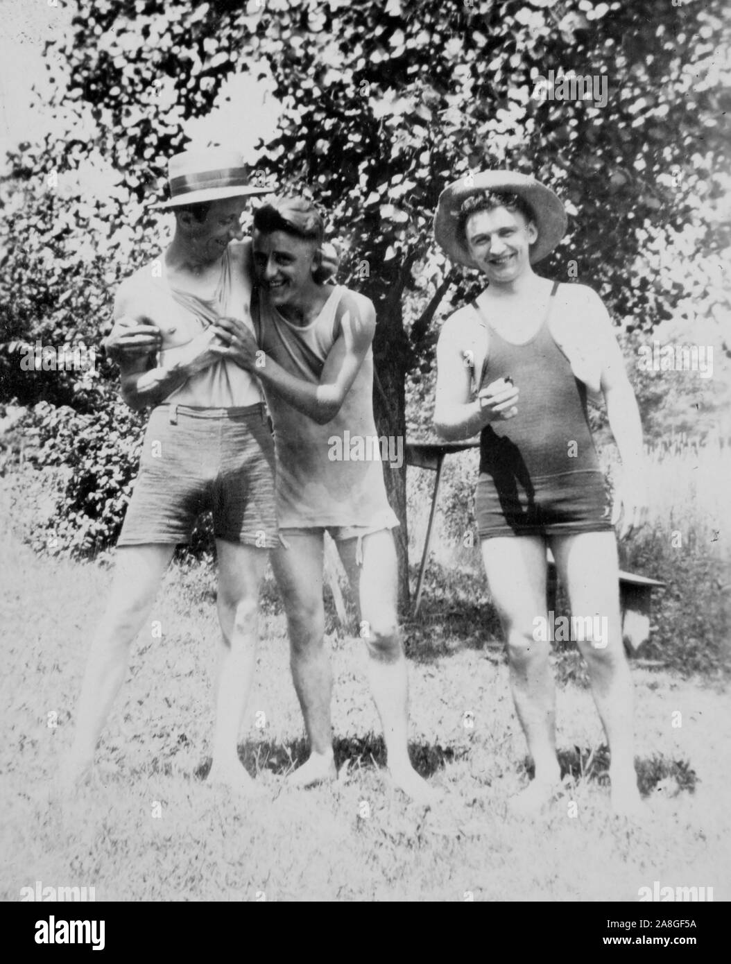 Tre ragazzi davvero pessimo periodo costumi clown intorno per un ritratto, ca. 1920. Foto Stock