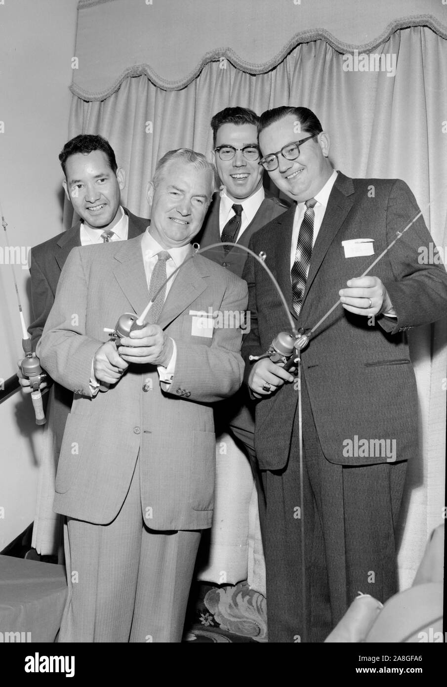 Geeky uomini bianchi controllare la mercanzia in una sporting goods convenzione in una foto promozionale nella California del Sud, ca. 1955. Foto Stock