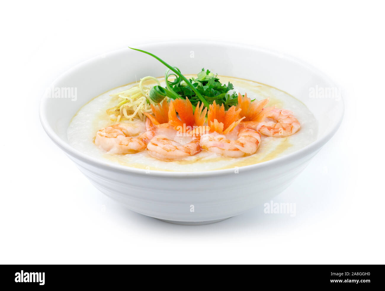 Congee Gamberetti ,farinata di riso servito fettina di zenzero e fettine di sedano,coriandolo erbe tailandese. Cibo asiatico prima colazione decorare con scolpite le carote e la molla Foto Stock