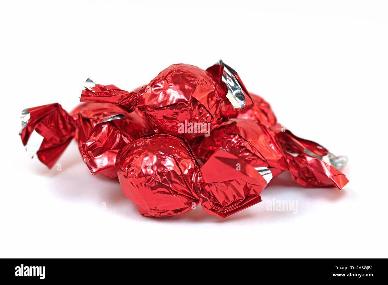 I dolci al cioccolato avvolto in un foglio di alluminio contro uno sfondo bianco Foto Stock