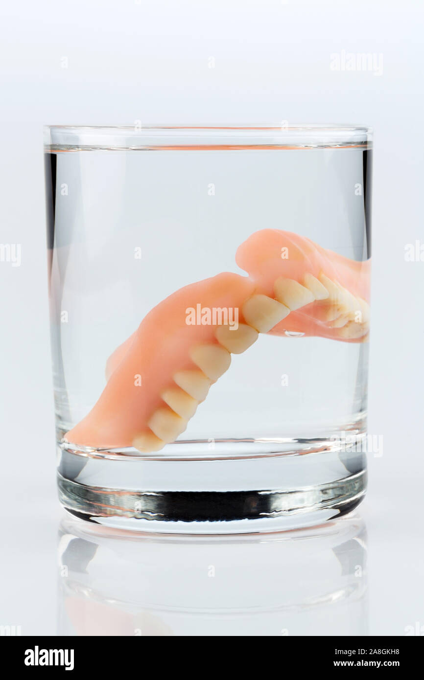 Zahnprothese m Wasserglas, Symbolfoto für Zahnersatz und Pflege Foto Stock