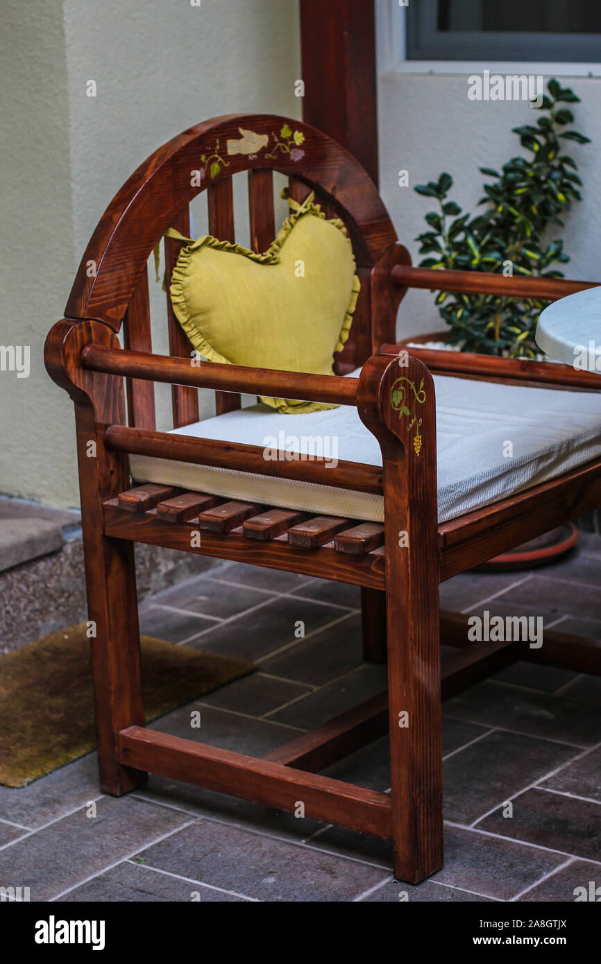 Sedia in legno con cuore giallo-cuscino sagomato e dipinto unico colomba e vite Foto Stock