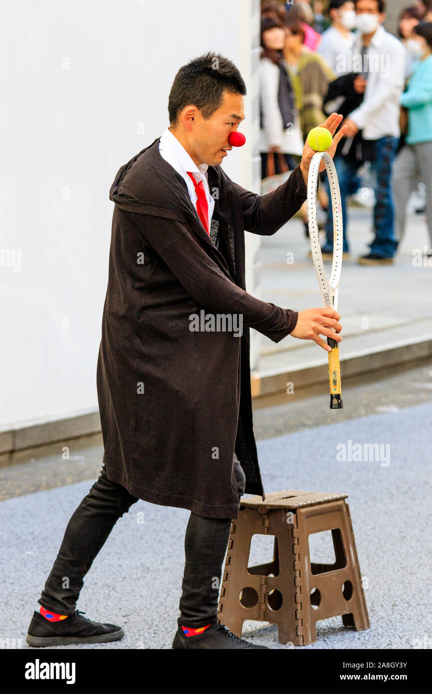 Tokyo, il Ginza. Weekend, zona pedonale di tempo permette street buskers da eseguire per gli amanti dello shopping. Giapponese bilanciamento uomo palla da tennis sulla sommità di racchetta Foto Stock
