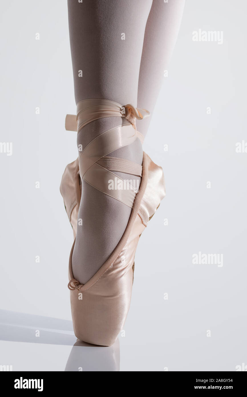 Ballerina classica con pointe scarpe in raso rosa in punta di piedi posizione Foto Stock