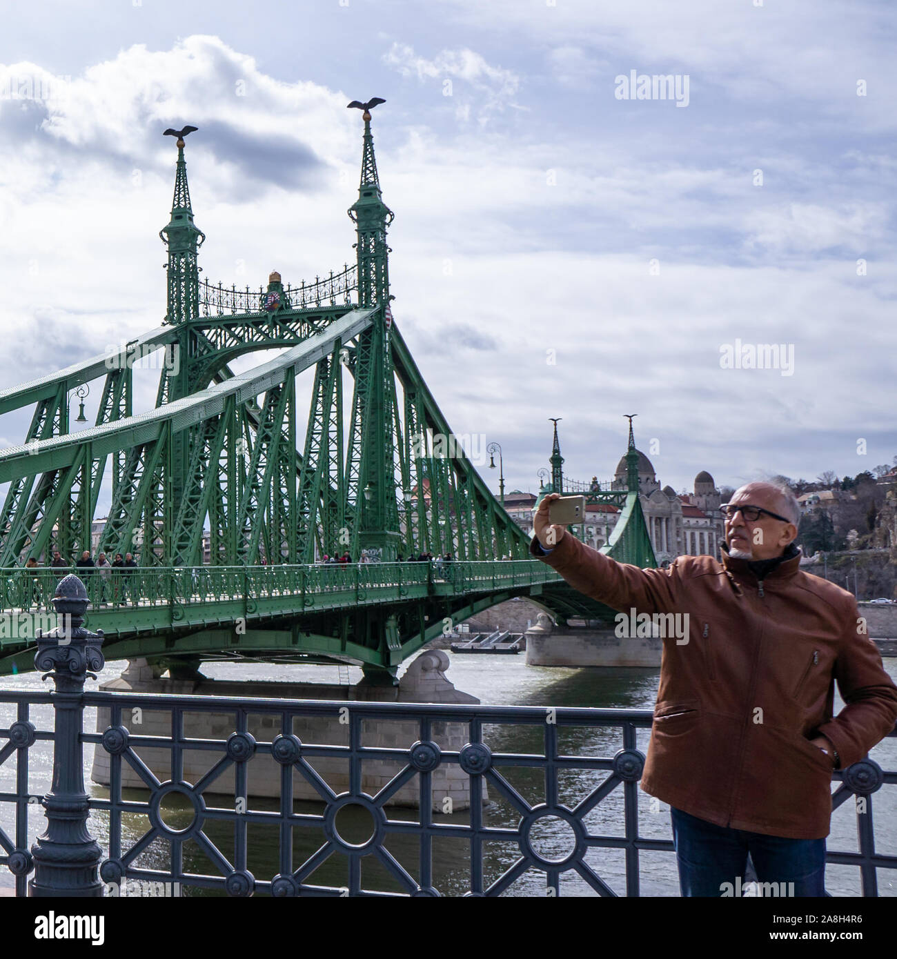 Budapest, Ungheria - 03 16 2019: turisti fanno un selfie utilizza lo smartphone su un ponte della Libertà (Szabadsag hid) di Budapest,l'Ungheria. Foto Stock