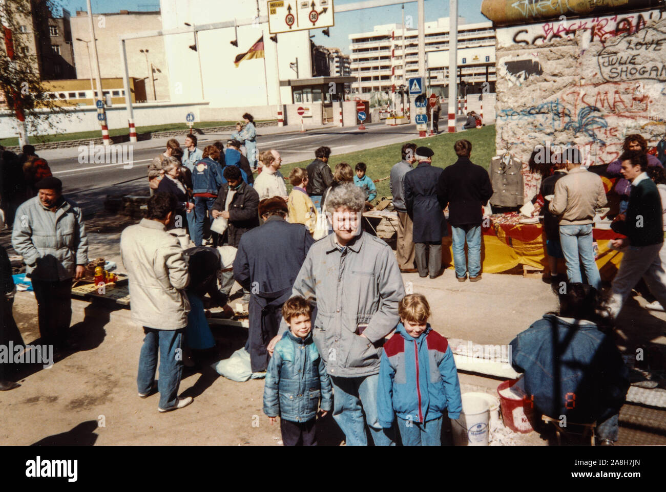 Michael Scott/Alamy Live News - Berlino, Germania Aprile 1990 - Vacanza le foto scattate in un mercato in stallo accanto a una sezione del muro di Berlino che vendono souvenir di pezzi di parete, uniformi militari e le immagini in Germania nel mese di aprile del 1990, pochi mesi dopo la caduta del muro di Berlino nel 1989. Foto Stock