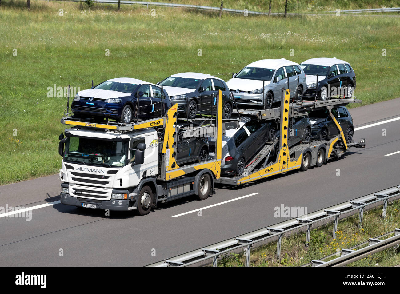 Altmann Scania auto-portante carrello caricato con nuova Volkswagen Golf su autostrada. Foto Stock