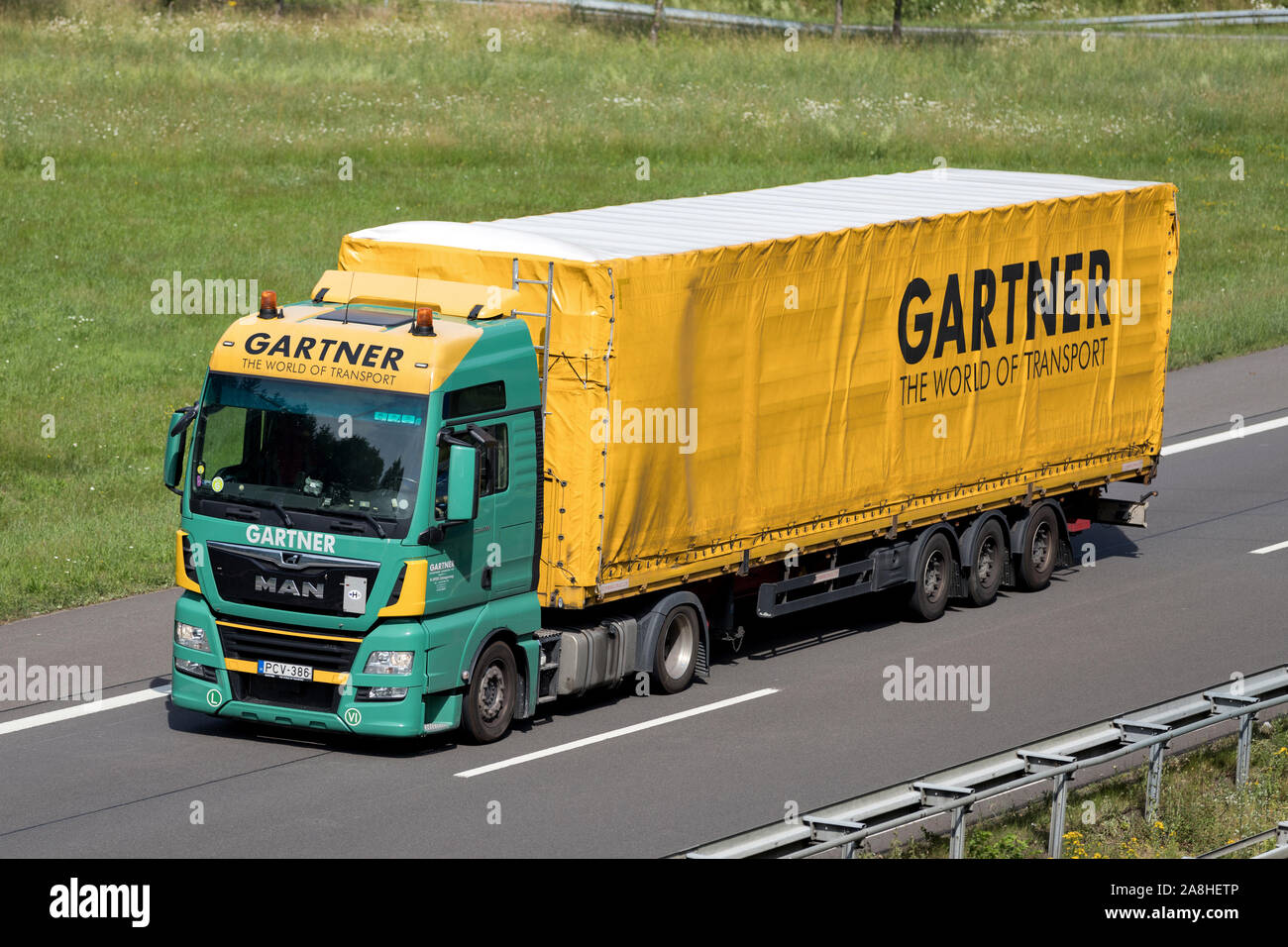 Gartner MAN TGX camion con rimorchio curtainside su autostrada. Foto Stock