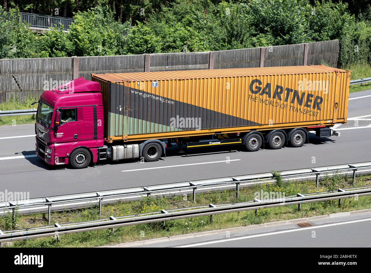 Gartner camion Man con contenitore rimorchio in autostrada. Foto Stock
