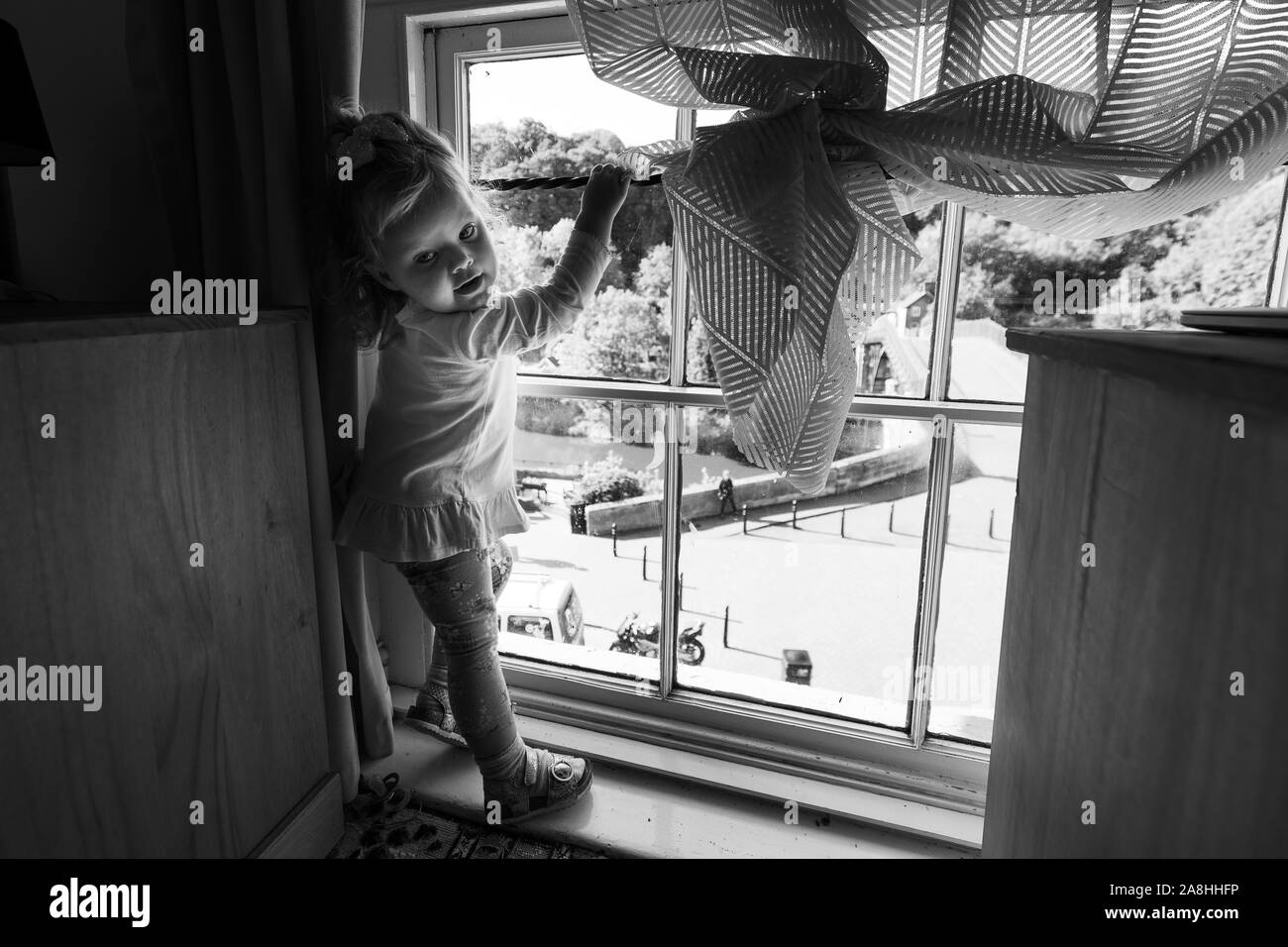 Un simpatico bambina sguardi fuori della finestra a Tontine hotel presso il famoso Ironbridge e casa di pedaggio, tempo per la famiglia e di alloggio, Tontine Hotel Foto Stock