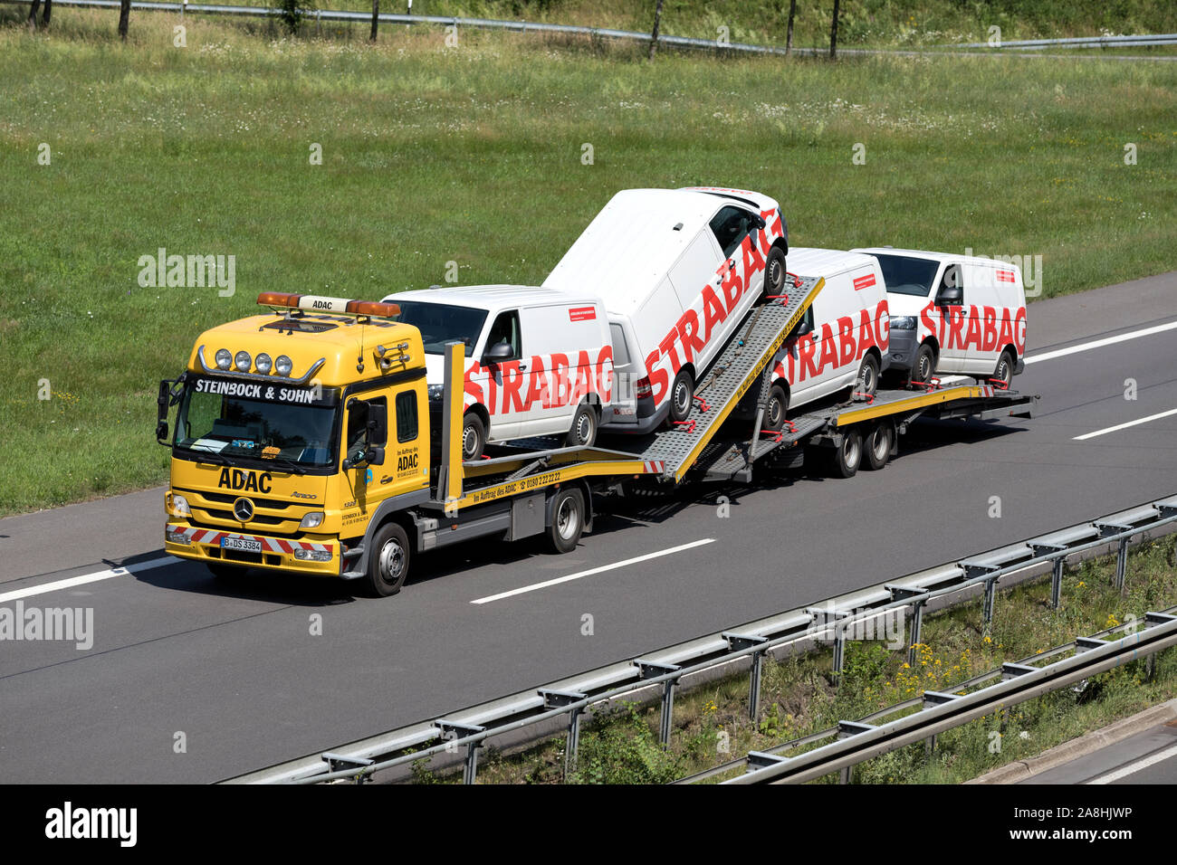 L'ADAC Mercedes-Benz Atego auto-portante carrello caricato con Strabag furgoni in autostrada. Foto Stock