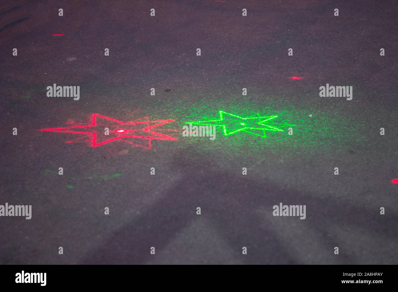 Il raggio laser sul asfalto stelle pattern. verde e rosa. sfondo spazio di copia Foto Stock