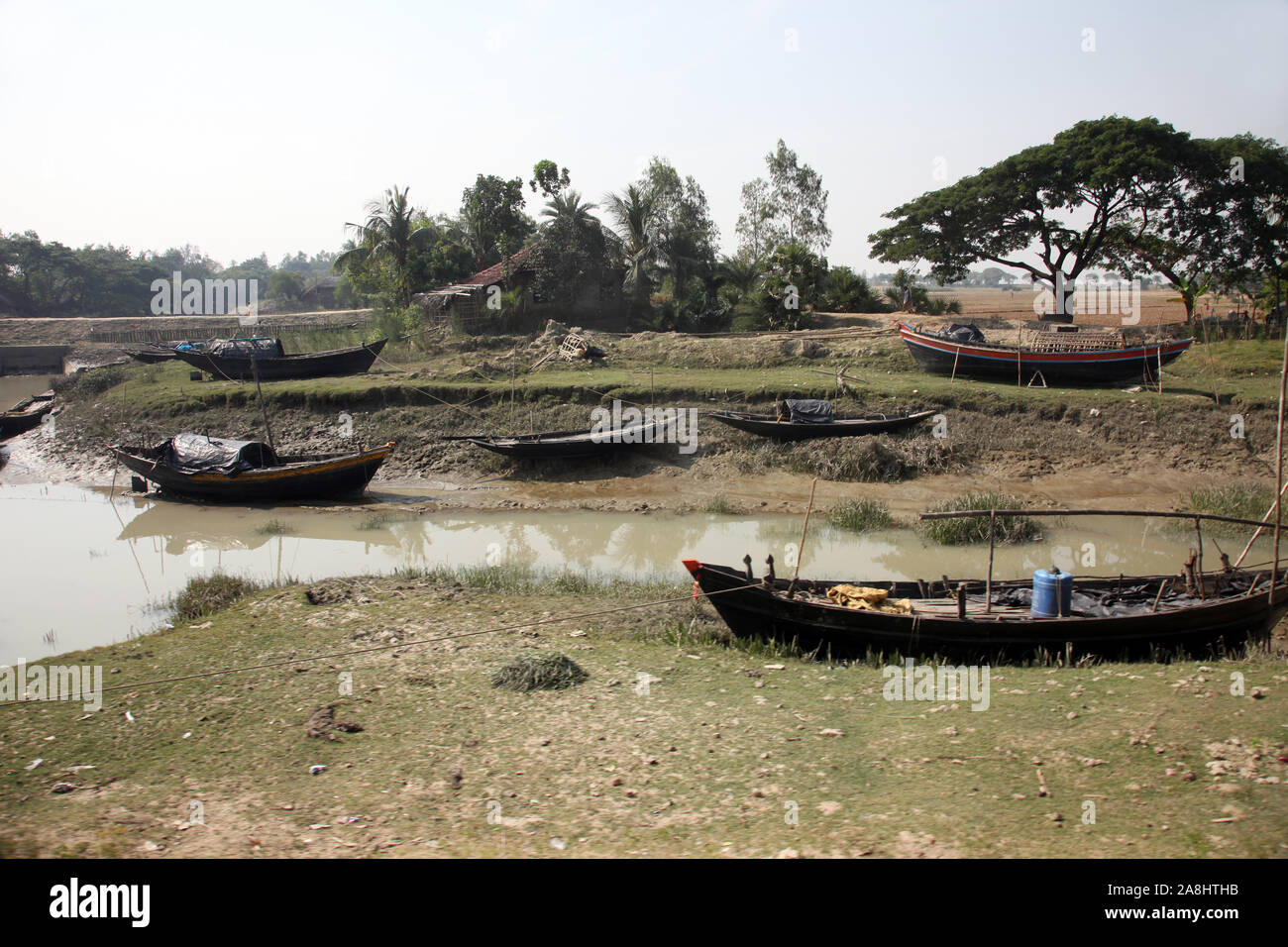 Le barche dei pescatori bloccati nel fango con la bassa marea sulla costa del Golfo del Bengala, India Foto Stock