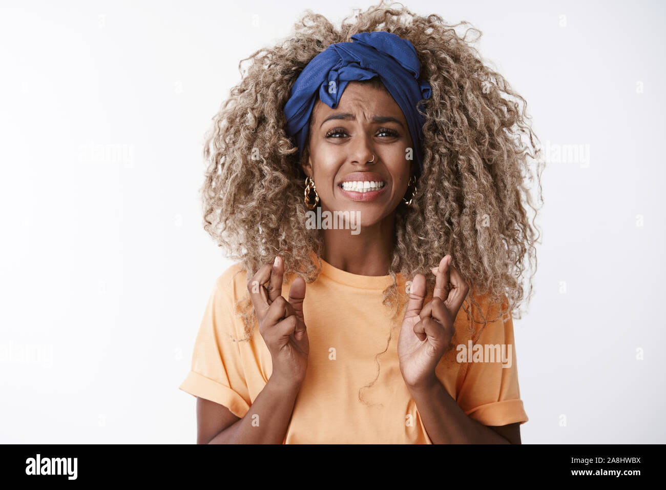 Close-up preoccupato e ansioso, turbato giovane disperato AFRICAN-AMERICAN curly donna bionda in t-shirt, fascia, stringono i denti sguardo disperato Foto Stock