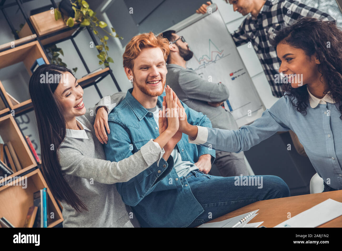 Startupers lavorando insieme a Office dando alta cinque allegro Foto Stock