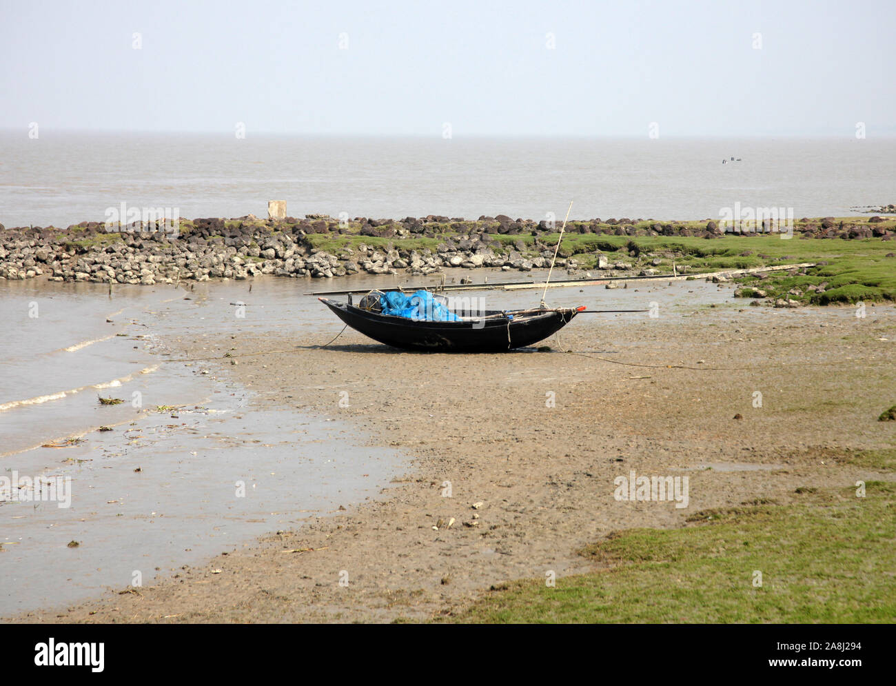 Le barche dei pescatori bloccati nel fango con la bassa marea sulla costa del Golfo del Bengala, India Foto Stock