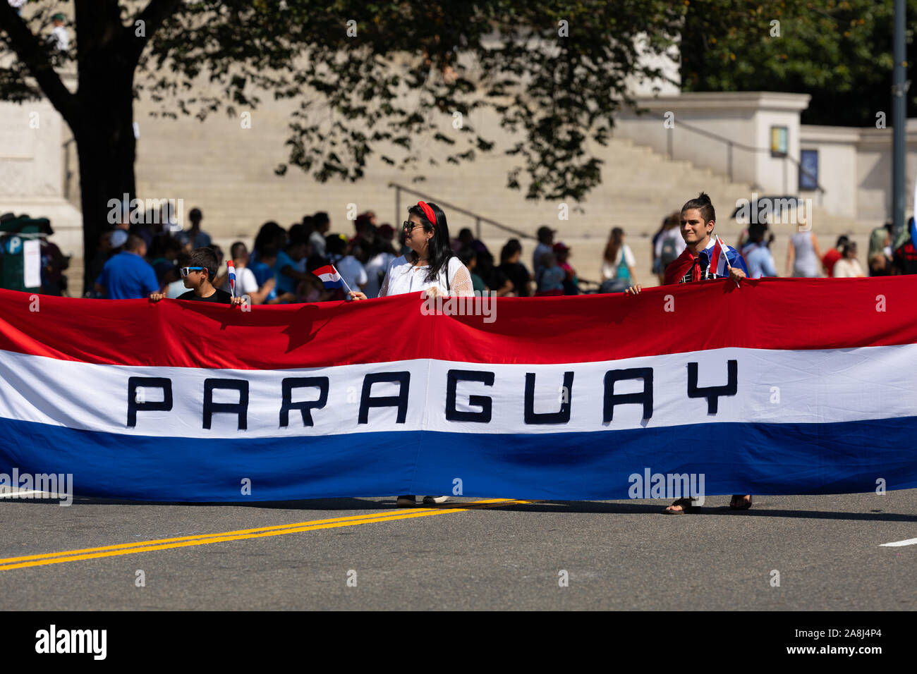 Washington DC, Stati Uniti d'America - 21 Settembre 2019: La Fiesta DC, Paraguayans portando un gigante bandiera nazionale verso il basso constitution avenue durante la sfilata Foto Stock