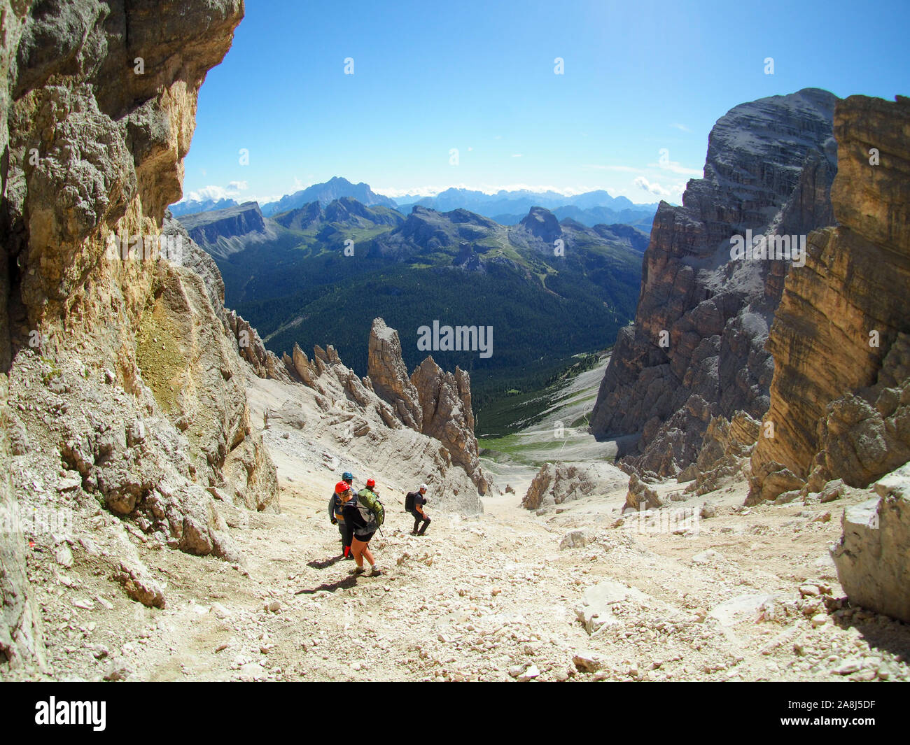 Un gruppo di alpinisti su un ripido ghiaione e rock discesa nelle Dolomiti in Italia in Alta Badia Foto Stock