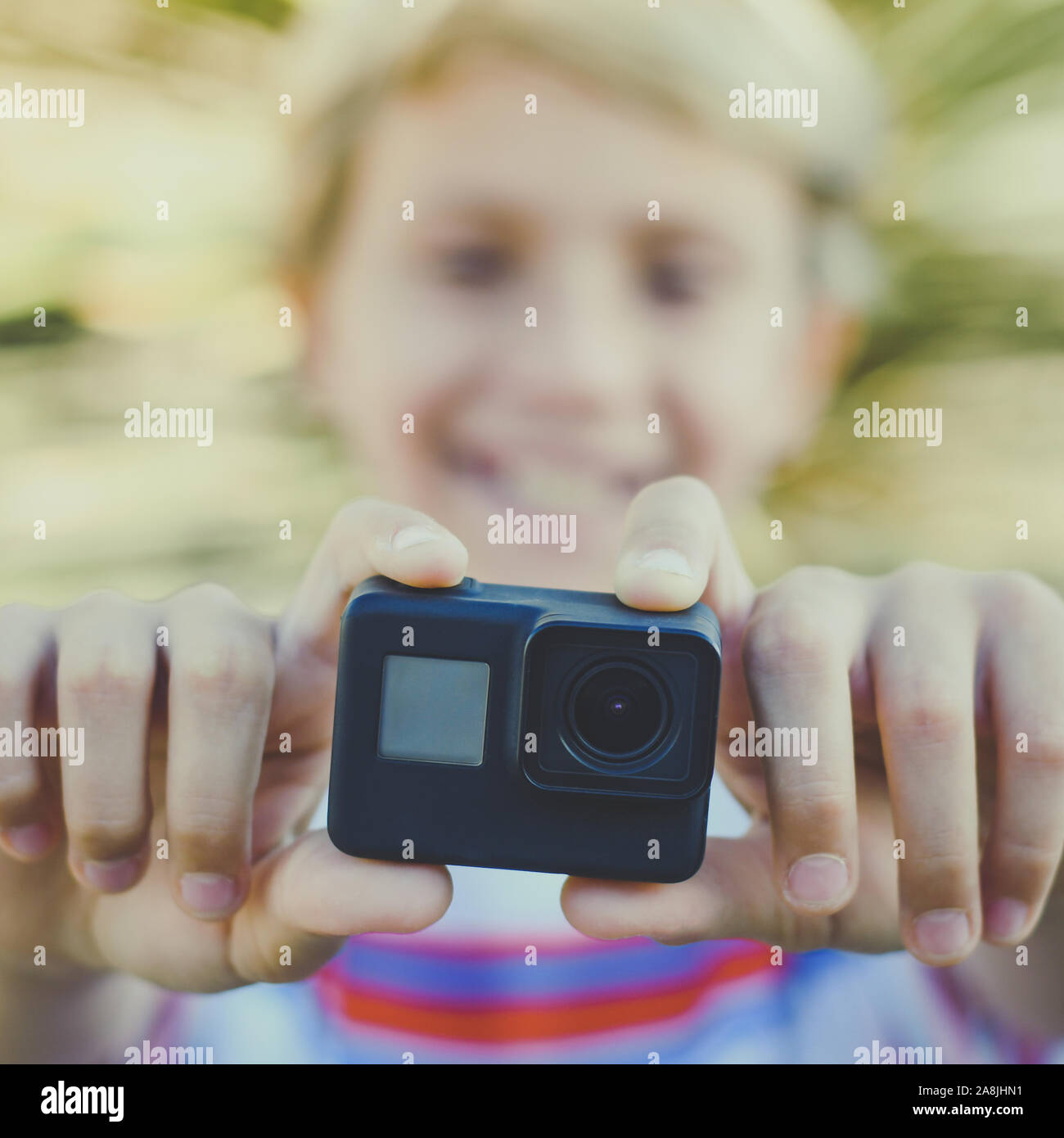 Vista ingrandita di un sorridente teen mediante azione camma. Giovani blogger rendendo video per la storia sociale con GoPro Camera. Studente divertirsi con nuove funzioni multimediali Foto Stock