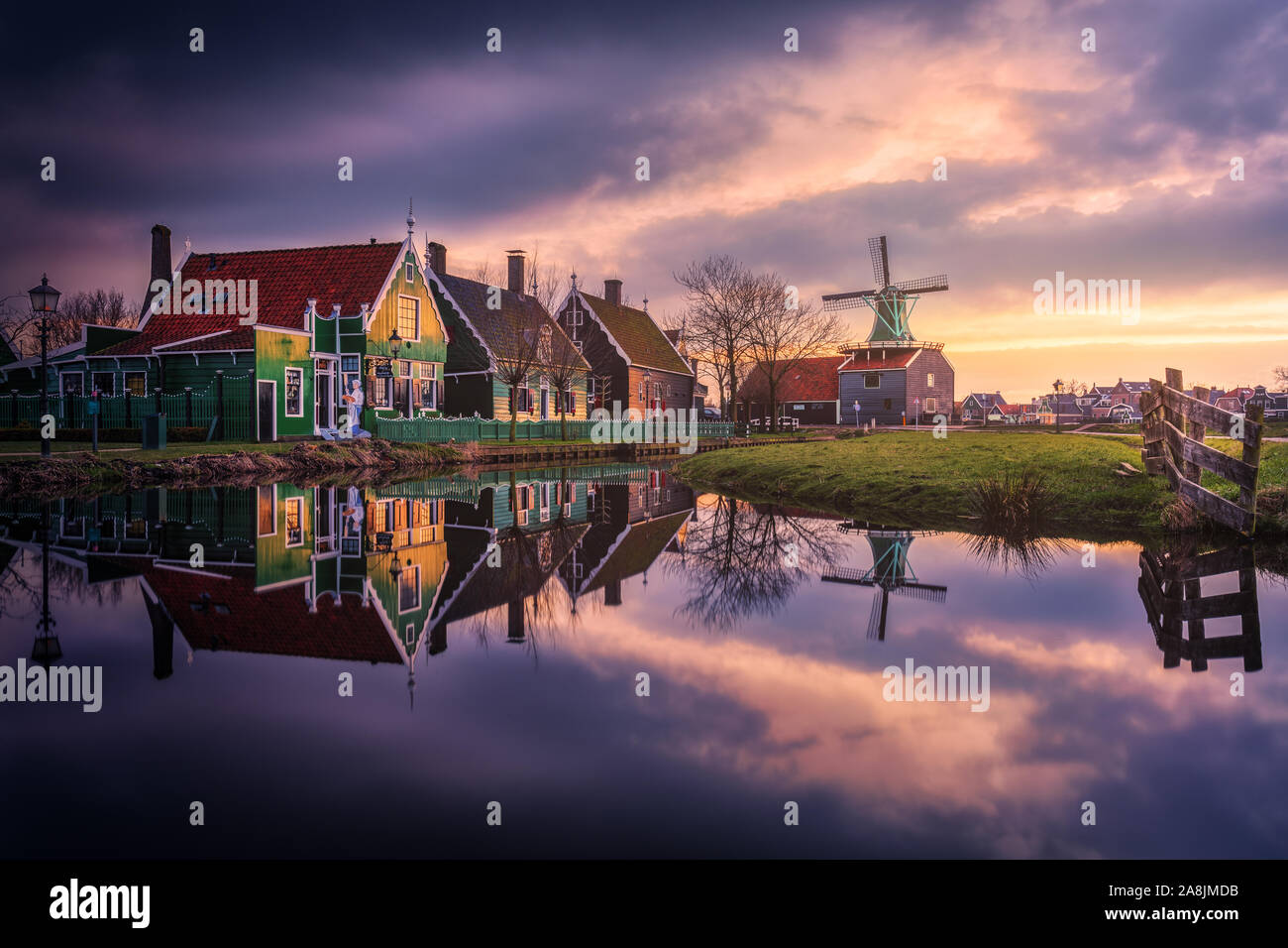 Zaanse Schans mulini a vento tradizionali nei Paesi Bassi. Bello e colorato nuvoloso sera. Acqua di riflessione. Foto Stock