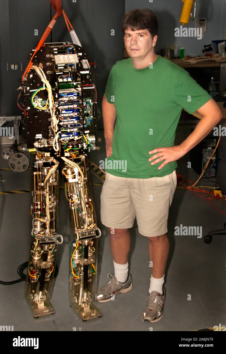 Research Scientist Jerry Pratt sta accanto a M2V2, un lifesize bipedal robot, presso l'Istituto per l'uomo e la macchina si dirigono in Pensacola, Florida. Foto Stock